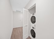 Thumbnail 41 of 49 - A white dryer is in a small room with a door open at Sky Central Apartments, Cincinnati, OH, 45202
