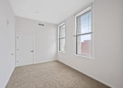 Thumbnail 29 of 49 - A room with a white door, carpeted floor, and a window with blinds at Sky Central Apartments, Cincinnati, 45202