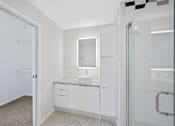 Thumbnail 37 of 49 - A bathroom with a sink, mirror, and cabinets at Sky Central Apartments, Cincinnati, OH, 45202