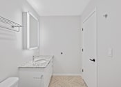 Thumbnail 39 of 49 - A white bathroom with a toilet, sink, and mirror at Sky Central Apartments, Ohio