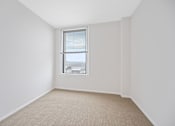 Thumbnail 30 of 49 - A room with a window and carpeted floor at Sky Central Apartments, Cincinnati, Ohio