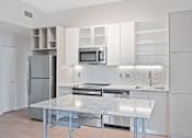 Thumbnail 28 of 49 - A modern kitchen with a granite countertop and stainless steel appliances at Sky Central Apartments, Cincinnati, OH