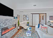 Thumbnail 5 of 49 - A living room with a fireplace and a couch at Sky Central Apartments, Cincinnati