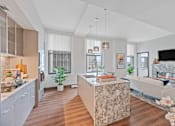Thumbnail 3 of 49 - A modern kitchen with a marble island and a living room with a fireplace at Sky Central Apartments, Ohio