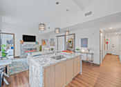 Thumbnail 2 of 49 - A modern kitchen with a marble island and pendant lights at Sky Central Apartments, Cincinnati, Ohio