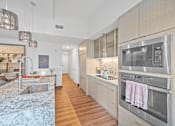 Thumbnail 1 of 49 - A modern kitchen with a stainless steel oven and wooden floors at Sky Central Apartments, Cincinnati, 45202