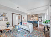 Thumbnail 6 of 49 - A living room with a white couch and a glass coffee table at Sky Central Apartments, Cincinnati, OH