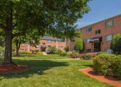 Thumbnail 11 of 34 - Exterior of apartment building with green landscaping at Woodlee Terrace Apartments, Virginia, 22192