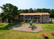 Thumbnail 6 of 18 - Far away view of apartment complex with playground at Gainsborough Court Apartments, Fairfax, VA
