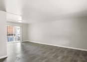 Thumbnail 27 of 69 - an empty living room with a sliding glass door to a balcony