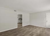 Thumbnail 46 of 69 - the living room of an apartment with white walls and wood flooring