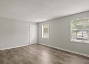 Thumbnail 43 of 69 - the spacious living room of an apartment with a white door and window