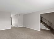 Thumbnail 58 of 69 - an empty living room with carpet and stairs in a house