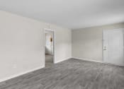 Thumbnail 15 of 69 - the living room of an apartment with white walls and wood flooring