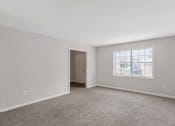 Thumbnail 49 of 69 - an empty living room with carpet and a window
