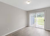 Thumbnail 51 of 69 - an empty living room with a sliding glass door to a yard