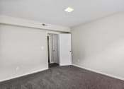 Thumbnail 13 of 69 - a bedroom with white walls and carpet and a door to a closet