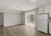 Thumbnail 40 of 69 - a kitchen and living room with white appliances and a sliding glass door