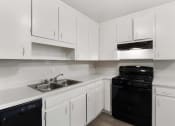 Thumbnail 1 of 69 - an empty kitchen with white cabinets and black appliances