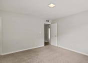 Thumbnail 41 of 69 - a bedroom with white walls and carpet and a door to a hallway