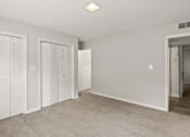 Thumbnail 33 of 69 - a bedroom with white closets and a carpeted floor