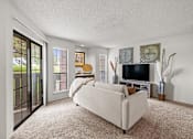 Thumbnail 10 of 37 - A living room with a white couch and a television.