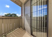 Thumbnail 17 of 37 - A balcony with a glass door and a wooden fence.