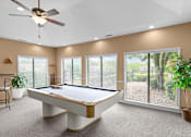 Thumbnail 32 of 37 - A pool table in a room with a ceiling fan and sliding glass doors.