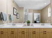Thumbnail 47 of 53 - A bathroom with two sinks and wooden cabinets.