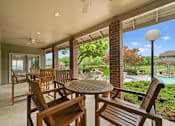 Thumbnail 25 of 37 - A patio with a table and chairs is shown.