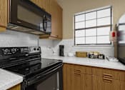Thumbnail 39 of 53 - Kitchen with black stove and microwave
