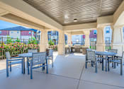 Thumbnail 21 of 38 - A patio with a table and chairs is surrounded by a fence.