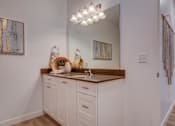 Thumbnail 9 of 38 - A bathroom with a white vanity and a mirror above it.