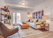 Thumbnail 5 of 38 - A living room with a brown chair and a white couch.