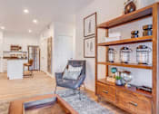Thumbnail 7 of 38 - A modern living room with a grey armchair and a wooden coffee table.