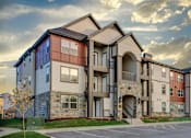 Thumbnail 33 of 38 - Apartment complex with a mix of beige, brown, and blue exterior colors.