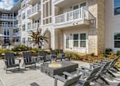 Thumbnail 9 of 18 - A patio with chairs and a table in front of a building.