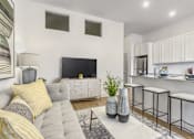 Thumbnail 4 of 18 - A modern living room with a grey couch and a grey coffee table.