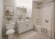 Thumbnail 10 of 28 - A white bathroom with a toilet, sink, and bathtub.