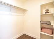 Thumbnail 15 of 20 - a walk in closet in a small room with shelves and a white wall