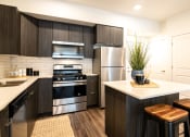 Thumbnail 5 of 20 - a modern kitchen with stainless steel appliances and black and white