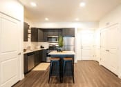 Thumbnail 6 of 20 - a kitchen with black and white cabinets and a counter top
