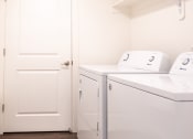 Thumbnail 16 of 20 - a laundry room with a washer and dryer and a white door