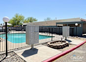 Thumbnail 10 of 18 - A pool with a diving board and a fence around it.