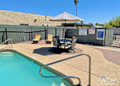 Thumbnail 5 of 18 - A pool with a warning sign and a table with chairs.