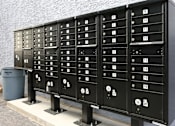 Thumbnail 12 of 13 - A row of black mailboxes with numbers on them.