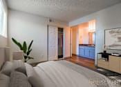 Thumbnail 6 of 13 - A bedroom with a large bed and a plant in a vase.