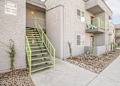 Thumbnail 9 of 13 - A building with a green staircase outside.