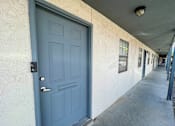 Thumbnail 13 of 27 - A blue door is on the left side of a white wall.