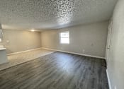 Thumbnail 15 of 27 - A room with a window and wooden flooring.
